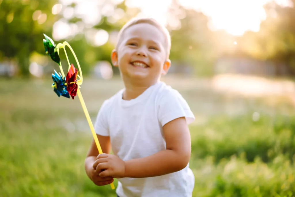 smiling child with toy in summer park on sunny day 2023 11 27 05 05 44 utc